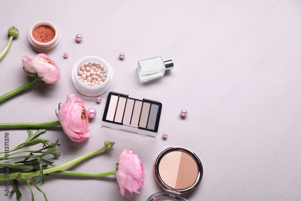 Naklejka premium Flat lay composition with different makeup products and beautiful spring flowers on gray background, space for text