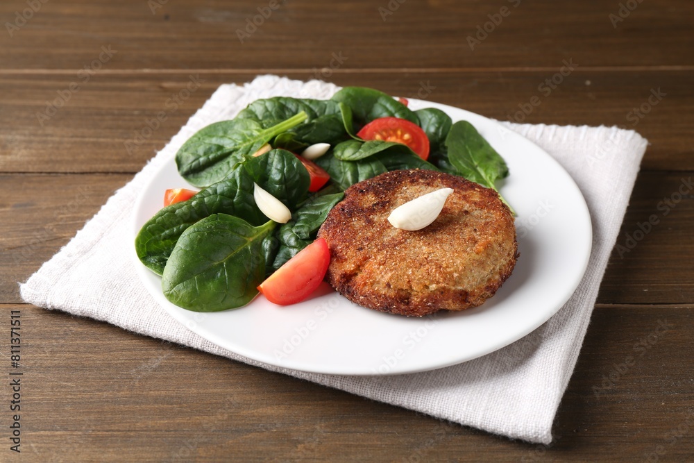 Tasty vegetarian cutlet and vegetables on wooden table Tasty vegetarian cutlet and vegetables on wooden table