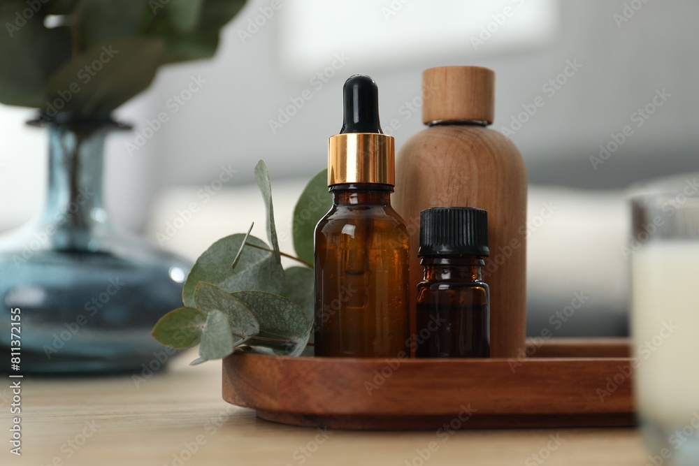 Aromatherapy. Bottles of essential oil and eucalyptus leaves on wooden table Aromatherapy. Bottles of essential oil and eucalyptus leaves on wooden table
