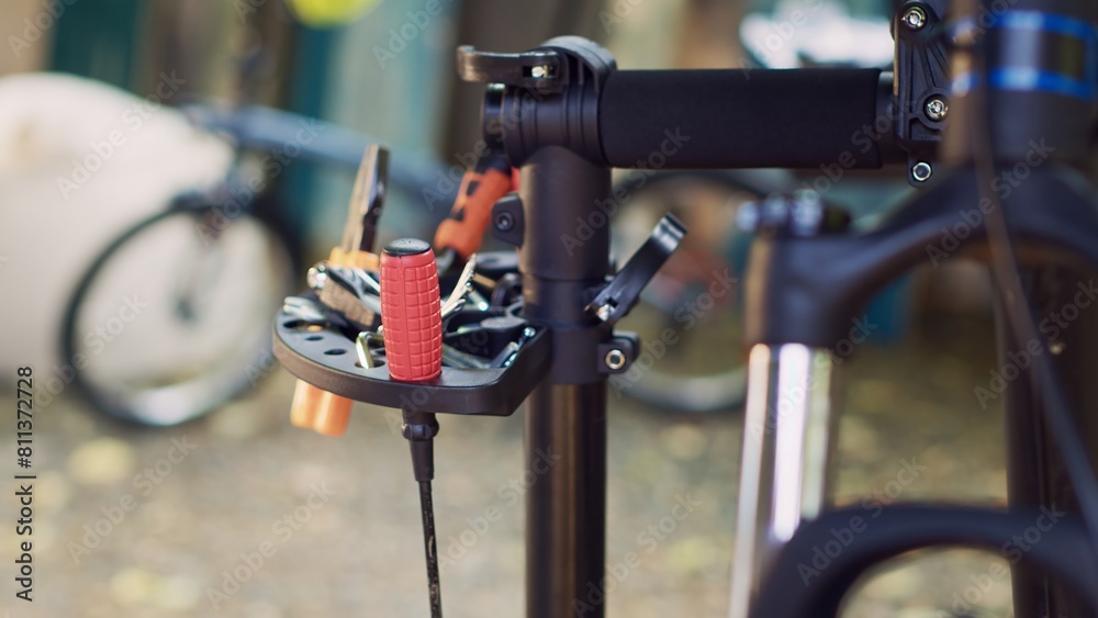 Zoom-in shot offering clear view of professional equipment displayed on repair-stand signifying readiness for bicycle maintenance outdoor. Various specialized work tools placed on bike workstand. Zoom-in shot offering clear view of professional equipment displayed on repair-stand signifying readiness for bicycle maintenance outdoor. Various specialized work tools placed on bike workstand.