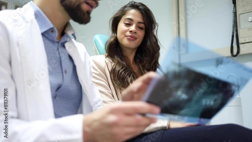 Young dentist explaining the treatment to his female patient