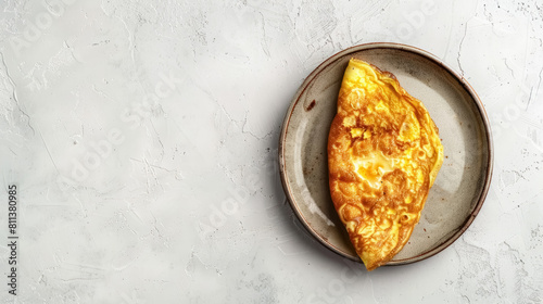 golden omelette on a rustic plate viewed from above on a light background, with copy space for text