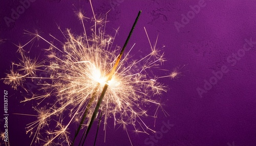 sparkler burning bright with shiny sparks dark purple festive background happy new year concept
