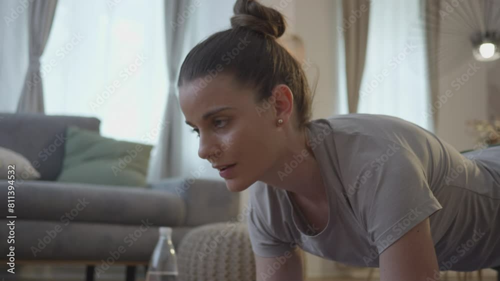 Young woman relaxing after holding plank position, face expression zoom in close up. Girl training muscles and standing on forearms while exercising on yoga mat. Strength and endurance concept Young woman relaxing after holding plank position, face expression zoom in close up. Girl training muscles and standing on forearms while exercising on yoga mat. Strength and endurance concept