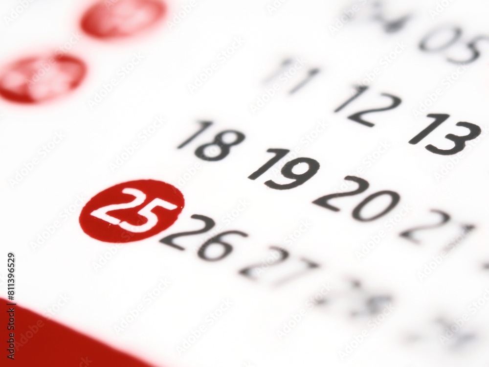 White paper calendar with the number 25 twenty-five in a red circle. The 25th twenty-fifth day of the month on a calendar White paper calendar with the number 25 twenty-five in a red circle. The 25th twenty-fifth day of the month on a calendar