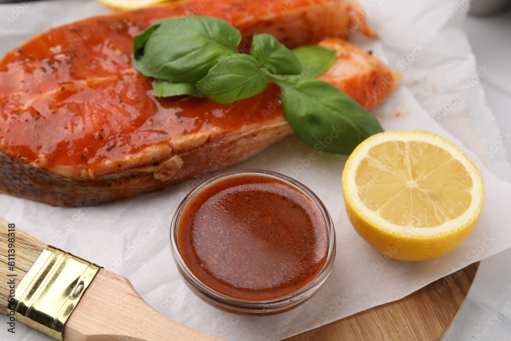 Fresh marinade, fish, lemon, brush and basil on table, closeup Fresh marinade, fish, lemon, brush and basil on table, closeup