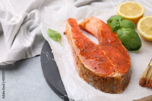 Fresh marinade, fish, lemon and basil on grey table, closeup