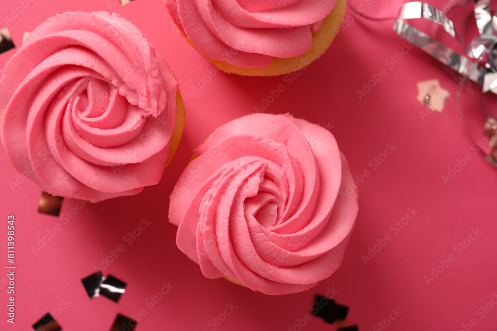 Delicious cupcakes with bright cream and confetti on pink background, flat lay Delicious cupcakes with bright cream and confetti on pink background, flat lay