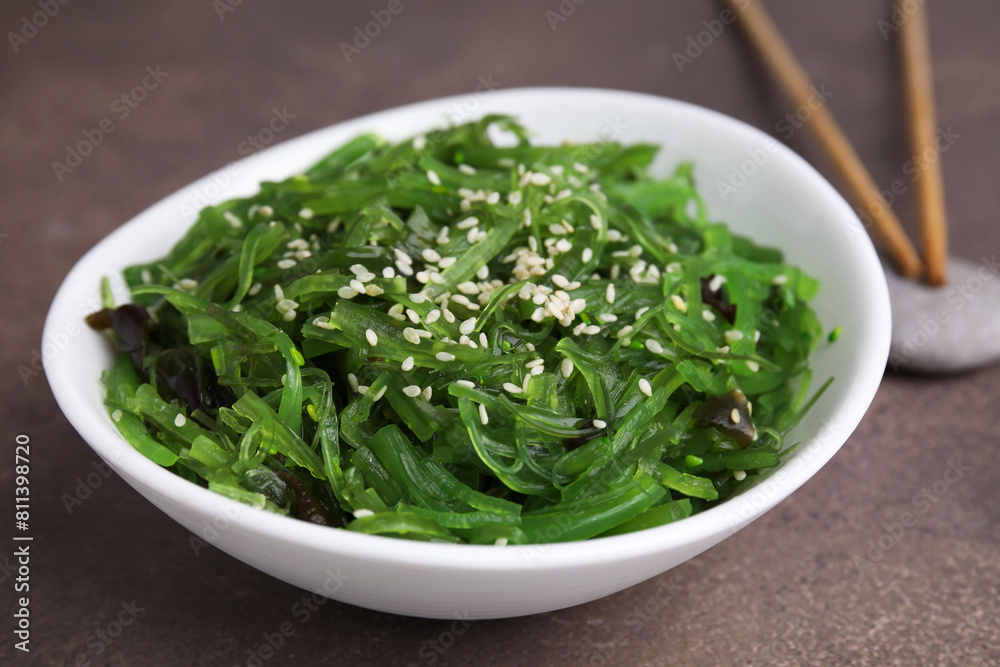 Tasty seaweed salad in bowl served on brown table, closeup Tasty seaweed salad in bowl served on brown table, closeup
