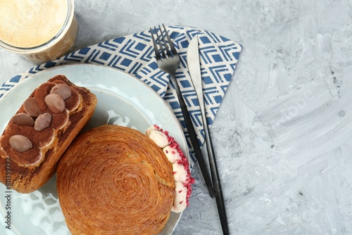 Tasty puff pastry. Round croissants served with coffee on light textured table, flat lay. Space for text photo