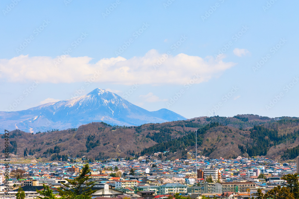 雪の残る磐梯山と会津若松市の街並み