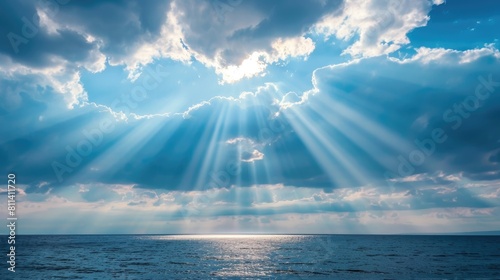 Light rays shining through clouds above the ocean