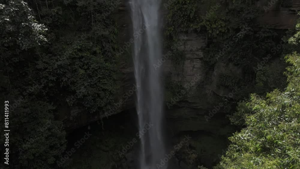 Drone hovers as camera pans down in front of waterfall Drone hovers as camera pans down in front of waterfall