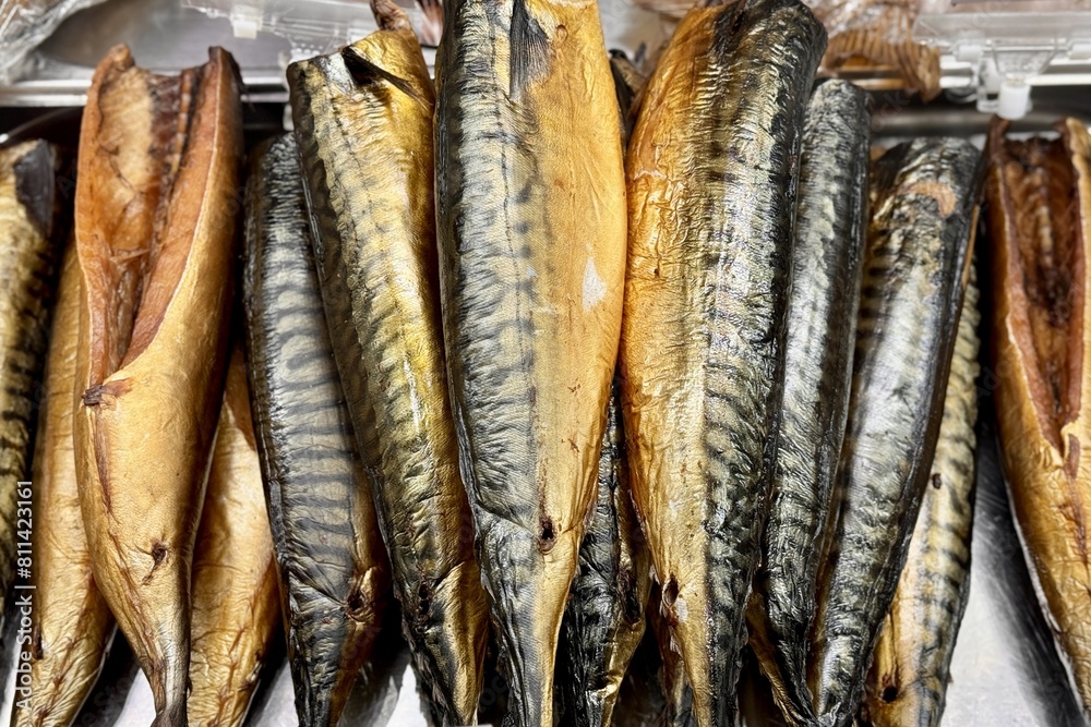 Atlantic mackerel cold smoked a lot of fish lies on a stainless steel baking sheet for snacks in a beer store. Close-up. Atlantic mackerel cold smoked a lot of fish lies on a stainless steel baking sheet for snacks in a beer store. Close-up.