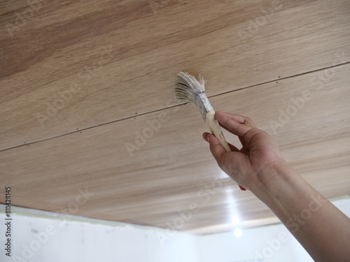 Painter applying wooden clear varnish