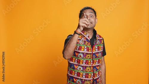 Disappointed indian man admonishing friend over debacle, isolated over studio background. Upset person in disagreement with mate, pointing finger and lecturing him, camera B photo