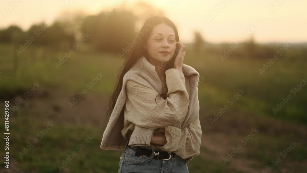 Pretty calm young woman with long dark hair enjoying beautiful countryside view of green field while walking down alone Pretty calm female exhaling fresh air relaxing on windy day outdoors Pretty calm young woman with long dark hair enjoying beautiful countryside view of green field while walking down alone Pretty calm female exhaling fresh air relaxing on windy day outdoors