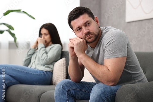 Фотография Offended couple ignoring each other after quarrel indoors, selective focus