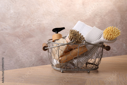 Fotografie Metal basket with brushes and cleaning tools on wooden table