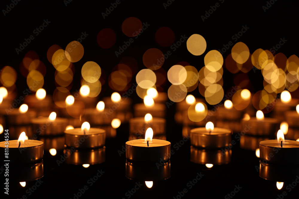 Burning candles on mirror surface in darkness, bokeh effect Burning candles on mirror surface in darkness, bokeh effect
