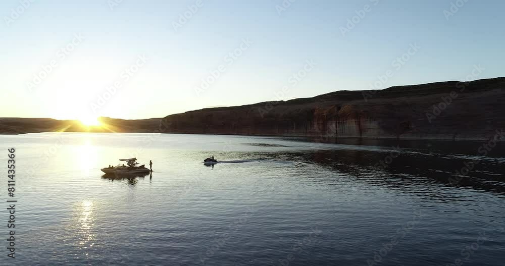 Drone shot flying over silhouetted boat and jet ski in lake Powell Drone shot flying over silhouetted boat and jet ski in lake Powell