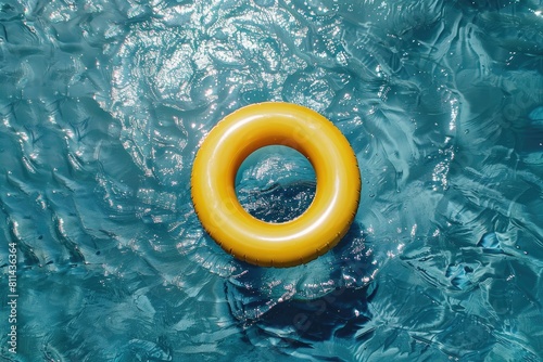 Yellow inflatable ring floating on swimming pool on summer background