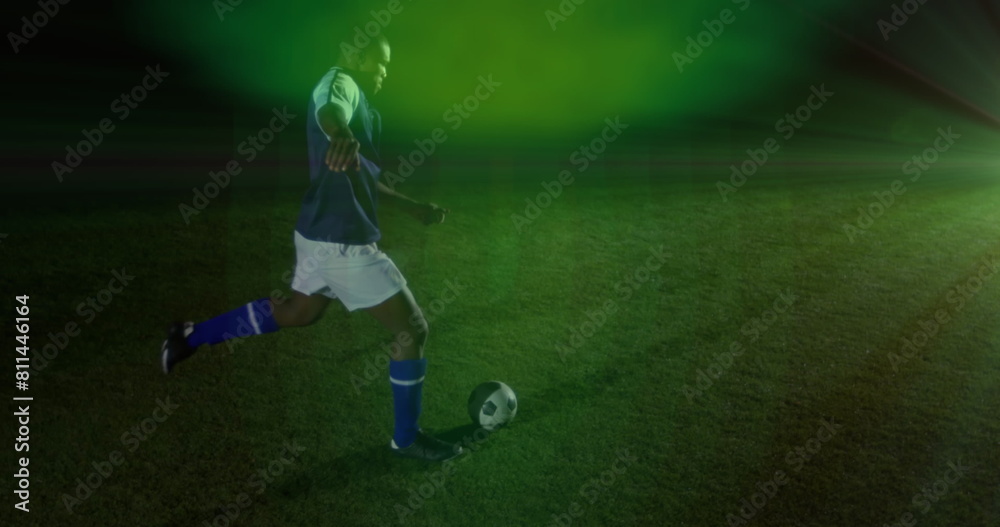 Image of green spot of light against african american male soccer player kicking the ball Image of green spot of light against african american male soccer player kicking the ball