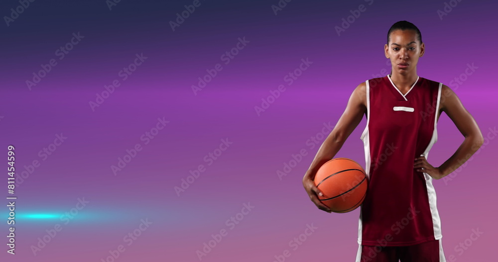 Φωτογραφία Image of female basketball player holding ball over glowing pink background
