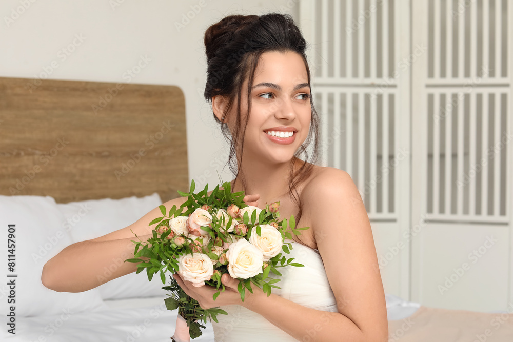 Young bride with wedding bouquet in bedroom Young bride with wedding bouquet in bedroom