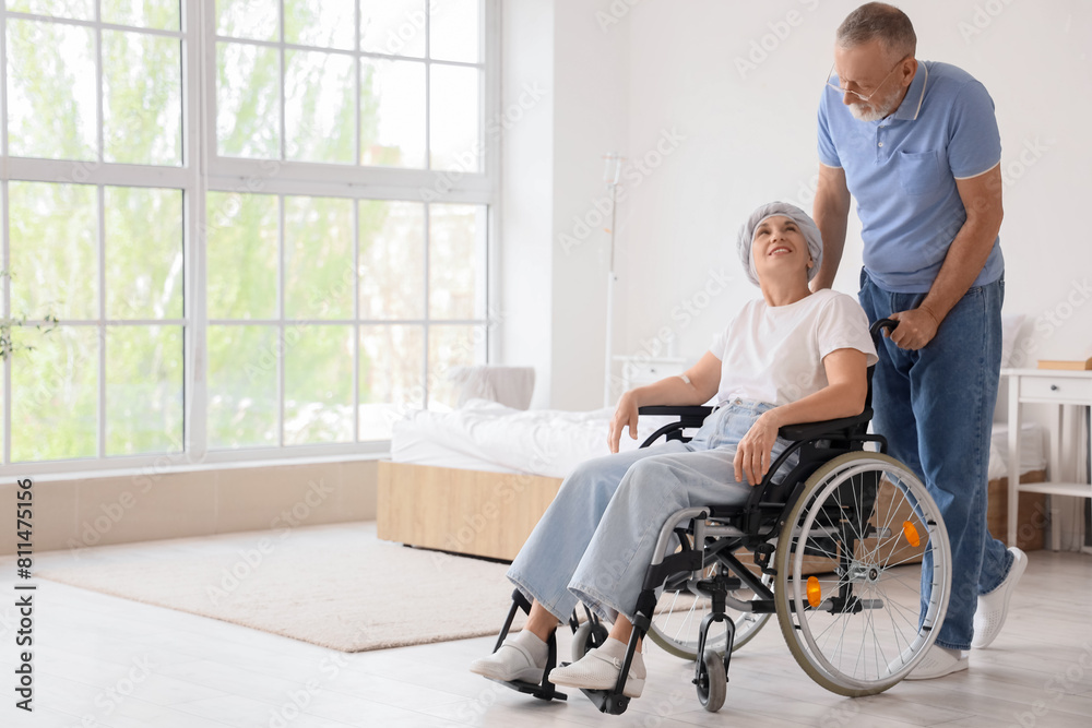 Mature woman after chemotherapy in wheelchair with her husband at home Mature woman after chemotherapy in wheelchair with her husband at home