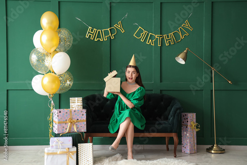 Young woman in party hat op...