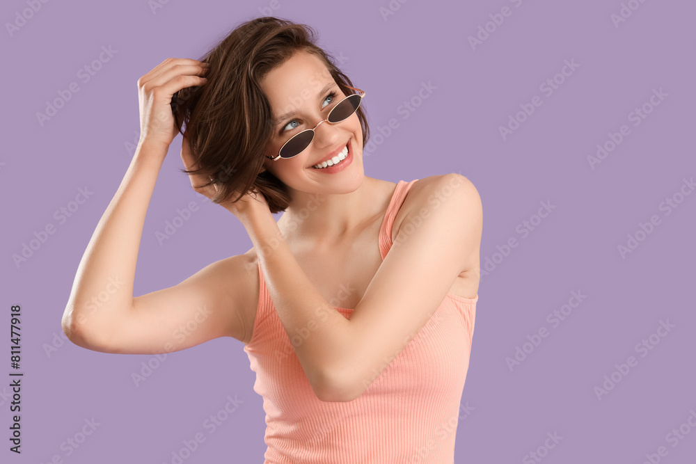 Pretty young woman with sunglasses on lilac background Pretty young woman with sunglasses on lilac background