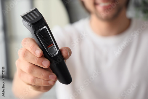 Obraz na płótnie Young bearded man with trimmer in bathroom, closeup