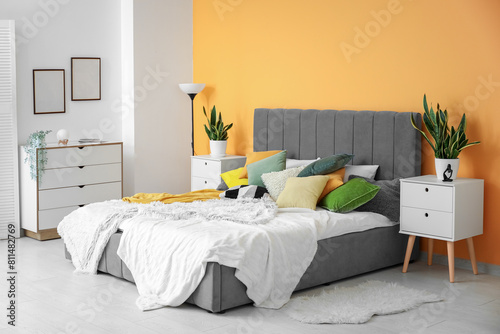 Stylish bedroom with bed, bedside table and chest of drawers