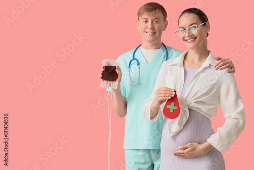 Young pregnant woman with paper drop and nurse holding blood pack for transfusion on pink background
