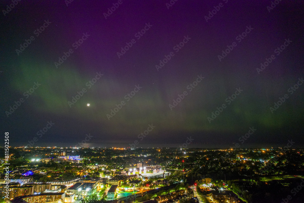 Fototapeta premium An aerial view of the Aurora Borealis over Cleveland, Ohio on May 5th, 2024. The Northern Lights are green near the horizon but became purple higher up and part of the city is visible.