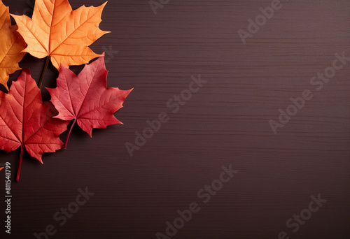 The background features red and orange maple leaves on the left side, with a dark brown wooden table in the center of the picture