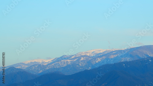 Landscape Panoramic View From Top Of Mountain. Mountain With Clouds And Blue Sky  Sun Coloring Clouds Orange.