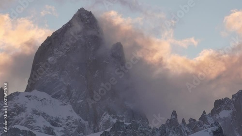 Mountain peak Fitz Roy surrounded by swirling clouds during a vibrant sunset, showcasing nature's grandeur photo