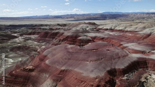 People on top of colorful mountains in Bentonite Hills, Utah, USA - Orbit, drone shot photo