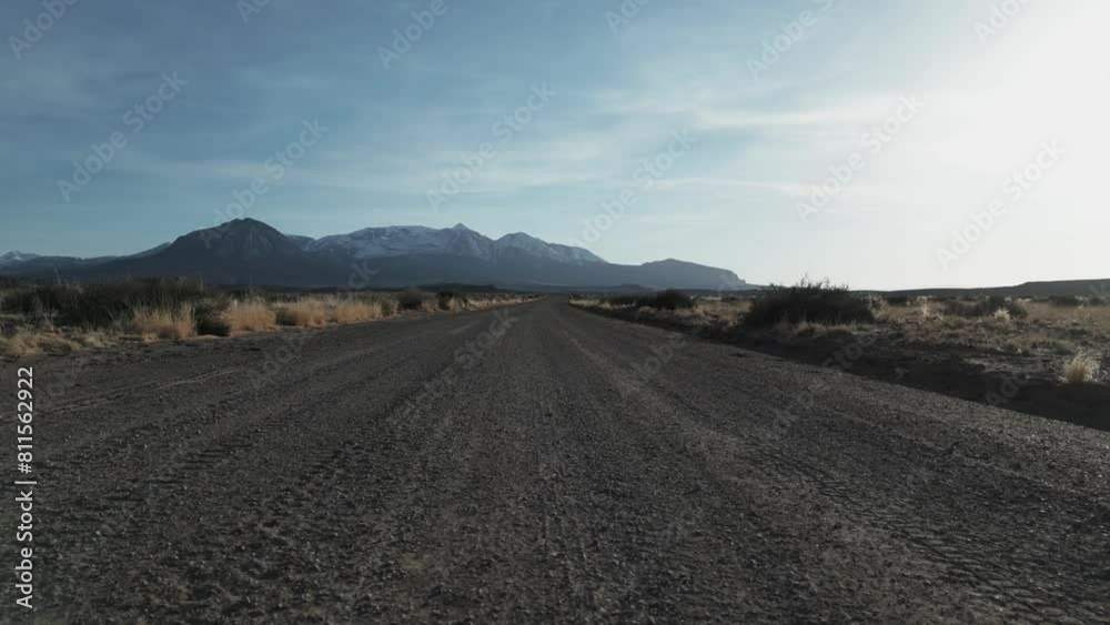 Aerial view of Utah desert vastness following the dirt road with mountains in background, USA Aerial view of Utah desert vastness following the dirt road with mountains in background, USA