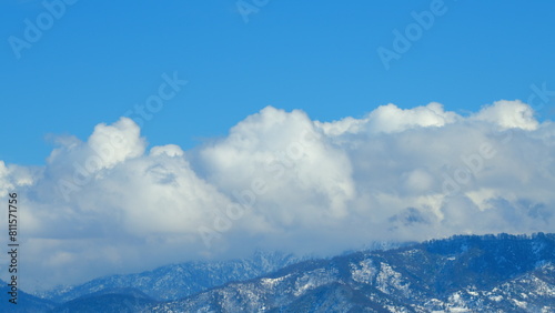 Mountains With Clouds Running Opposite Direction On Blue Sky. Snow-Covered Hills Of Mountains. Timelapse.
