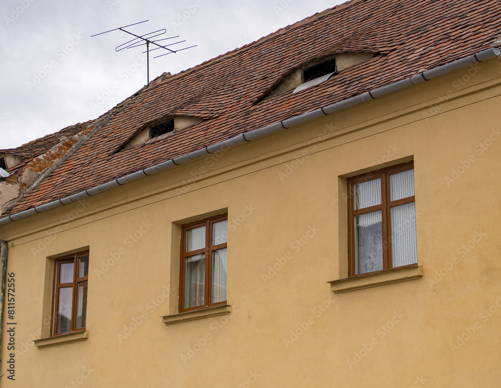 Red clay tiled roof with eye-like windows in the old town of Sibiu, Transylvania, Romania. Old houses with eyes are symbol of Sibiu Red clay tiled roof with eye-like windows in the old town of Sibiu, Transylvania, Romania. Old houses with eyes are symbol of Sibiu