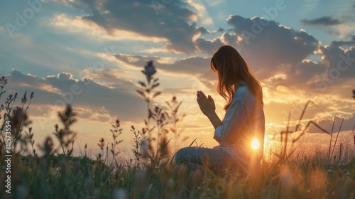  woman kneeling down praying for worship God at sky background, Christians pray to jesus christ for calmness, In morning people got to a quiet place and prayed photo