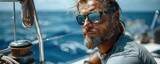 Bearded brutal handsome yacht owner in sunglasses on vessel deck looking forward in open ocean horizon while deep sea tuna fishing. Fierce fisherman conquering the deep sea.