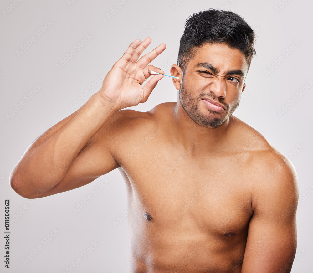 Fototapeta premium Man, cotton swab and ear with cleaning in morning for grooming or health on white background. Skincare, cosmetics and hygiene for self love with wellness or routine with treatment for hearing.