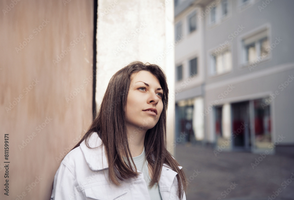 Young Woman in a White Jacket Contemplating on an Urban Street Young Woman in a White Jacket Contemplating on an Urban Street