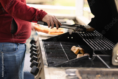Man grilling delicious brats and hotdogs outdoors