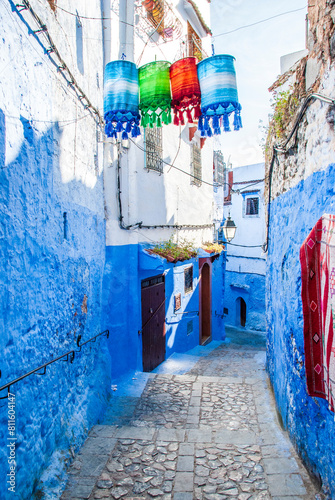 Beautiful moroccan blue streets in Chefchaouen. Bue city in Morocco with blue walls, architectural details, colorful flower pots and household items © Xandra