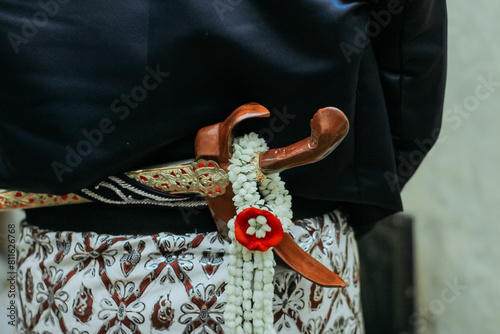 Beskap is an Indonesian traditional dress for the Javanese people. Keris is a traditional Javanese weapon that is usually tucked in a beskap. Usually used for traditional events such as weddings. photo